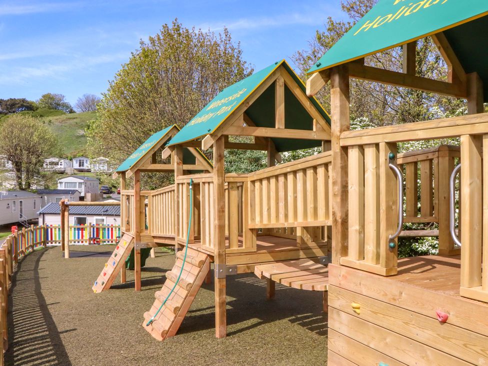 A playground structure with slides and climbing walls at 213 Seaview Caravan