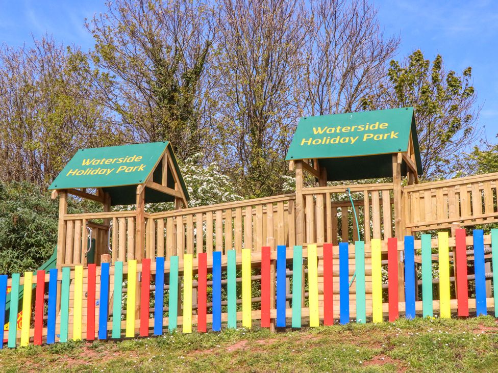 A playground structure with a sign at Waterside Holiday Park