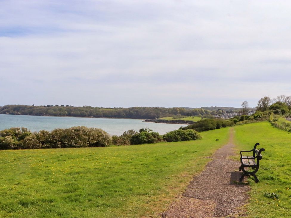 A bench next to a path by the water at 213 Seaview Caravan