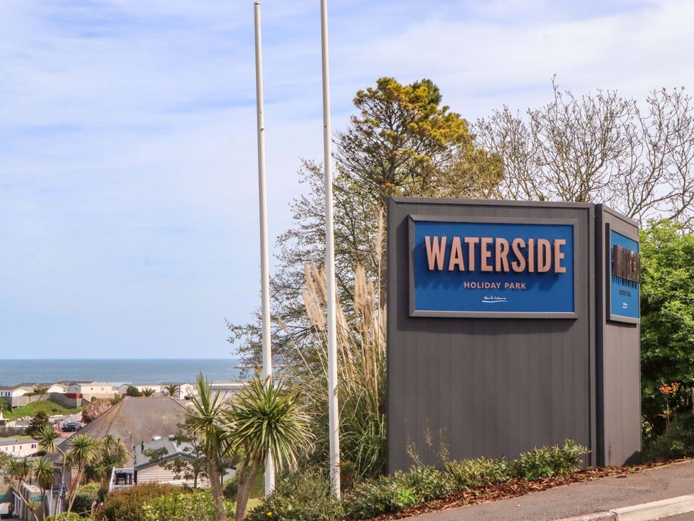 A sign for Waterside Holiday Park with ocean view