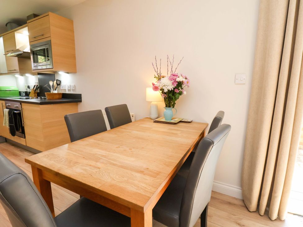 A dining room with a wooden table and chairs at Driftwood in Filey