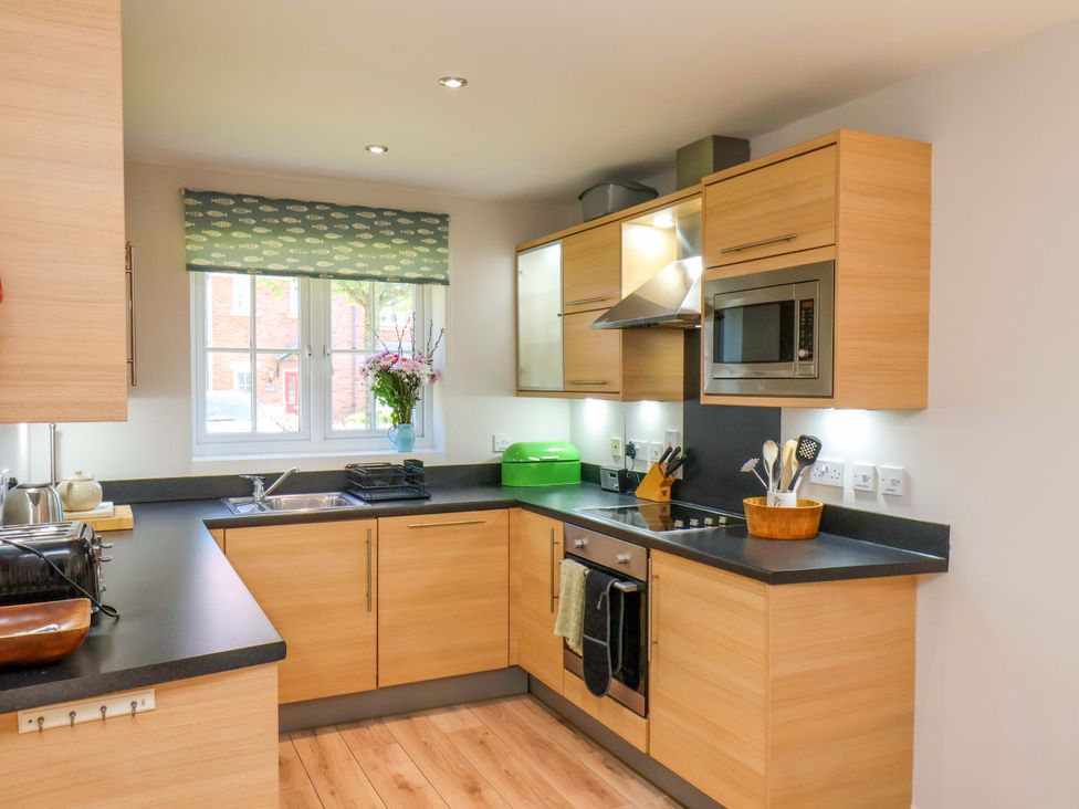 A kitchen with cabinets and appliances at Driftwood in Filey