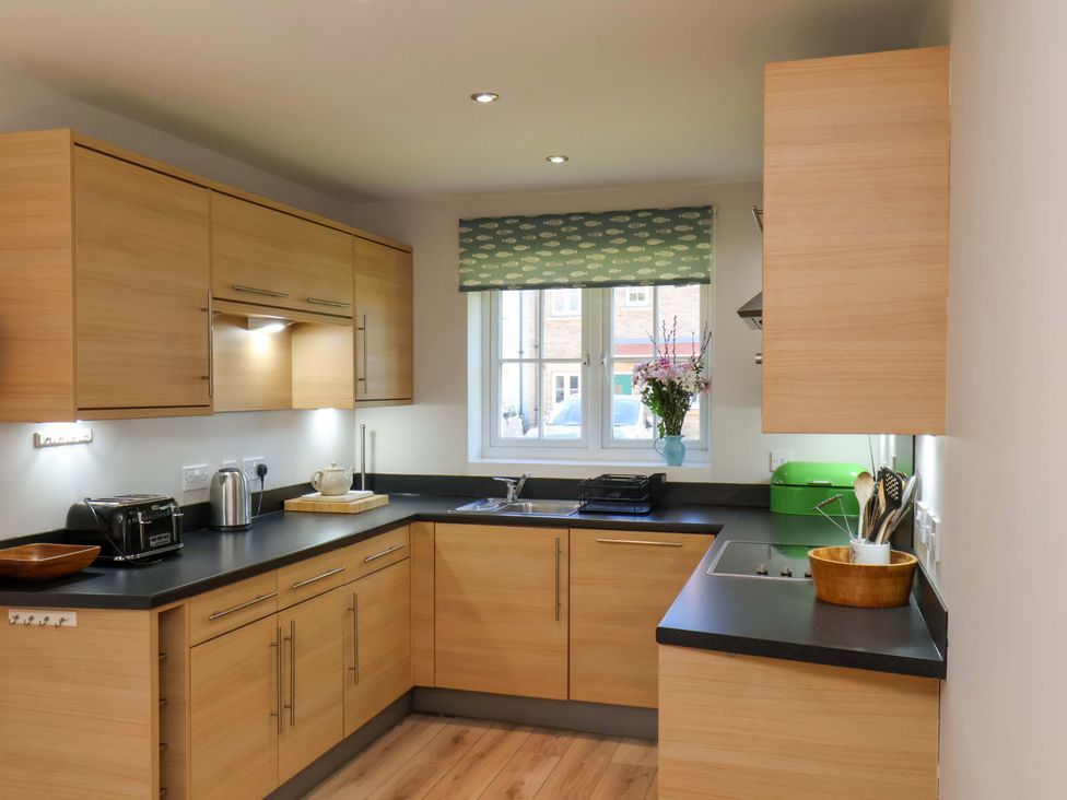A kitchen with wooden cabinets and a sink at Driftwood in Filey