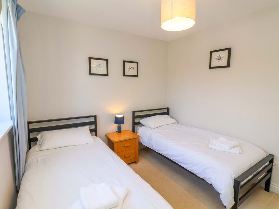 A bedroom with two beds and a lamp at Driftwood in Filey