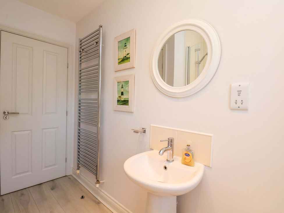 A bathroom with a sink and towel radiator at Driftwood in Filey