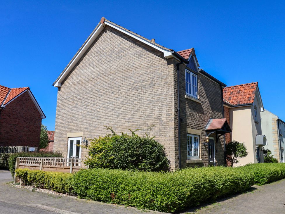 A house with a garden and blue sky at Driftwood in Filey