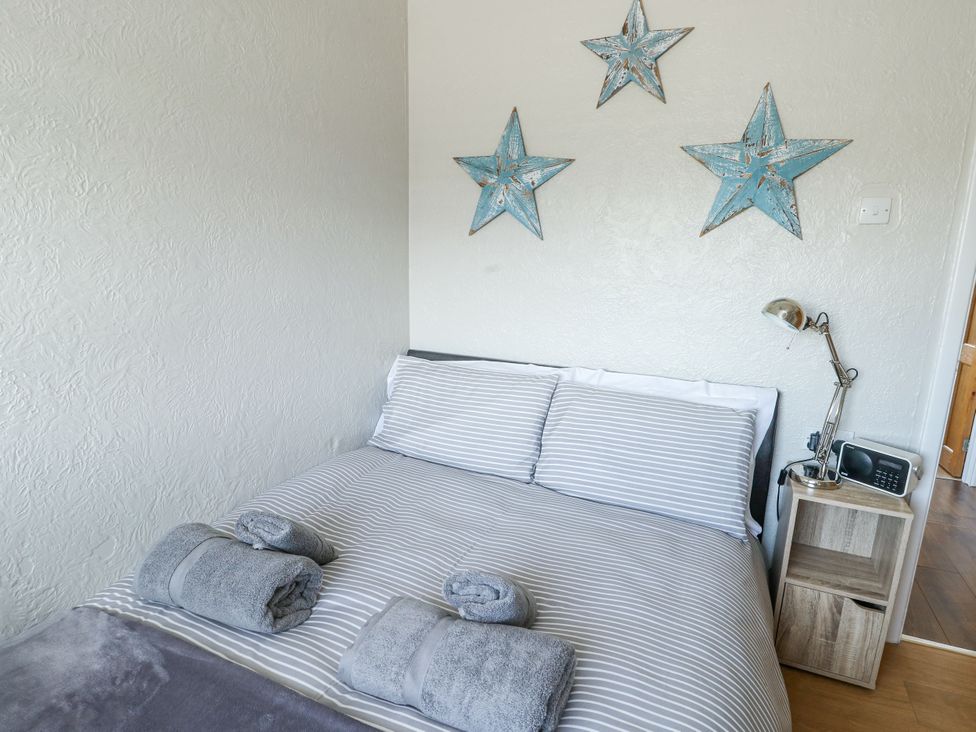 A bedroom with a bed and decorative stars at Fern Hill Cottage Newborough