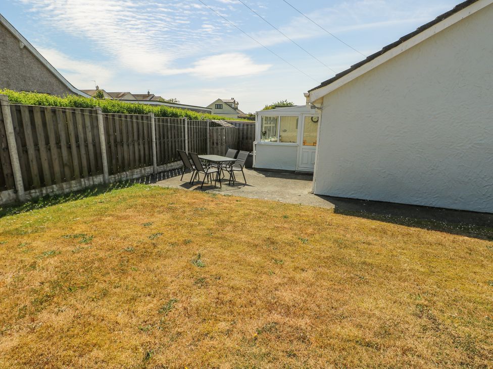 A garden with a table and chairs at Fern Hill Cottage in Newborough