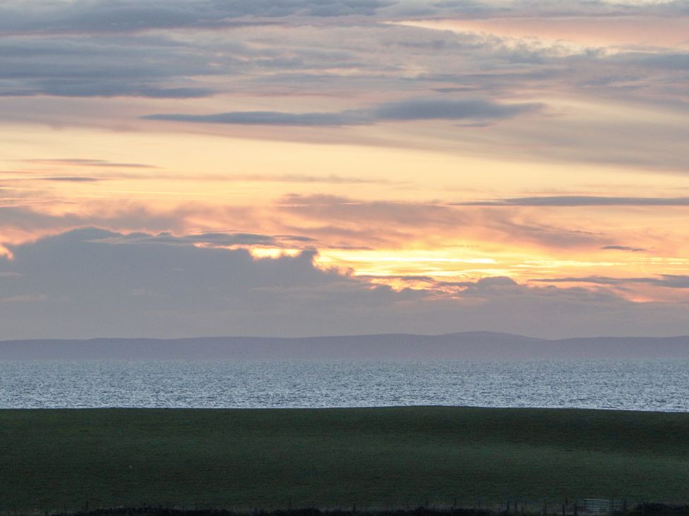 A view of the ocean and clouds during sunset at Squirrel Cottage in Kirkcolm