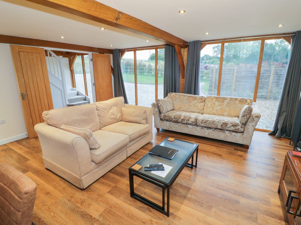 A living room with two sofas and a coffee table at The Coach House in Chacombe