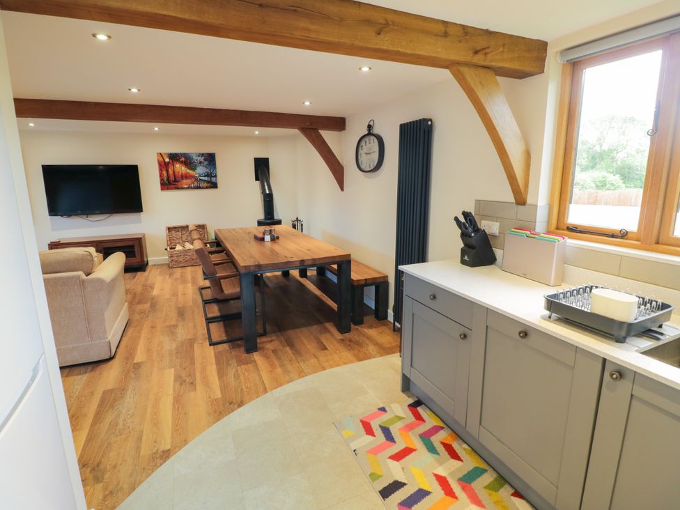 A living room with a sofa and dining area at The Coach House in Chacombe