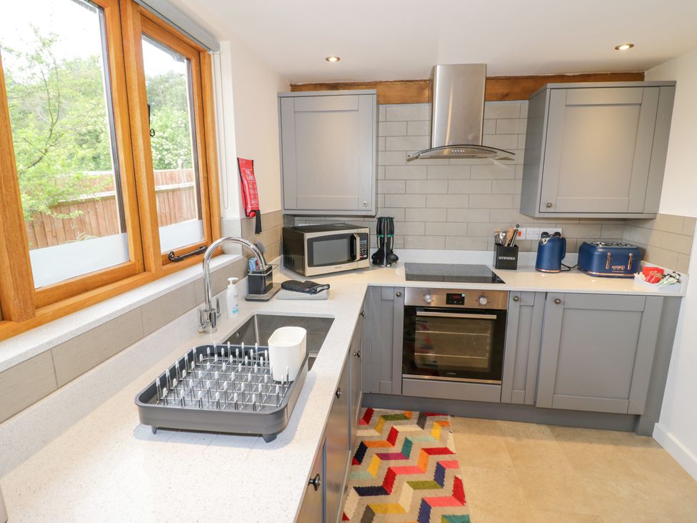 A kitchen with a sink and appliances at The Coach House in Chacombe