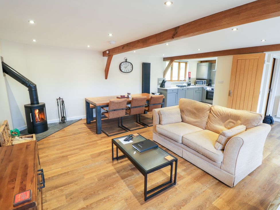 A living room with a sofa and dining area at The Coach House in Chacombe