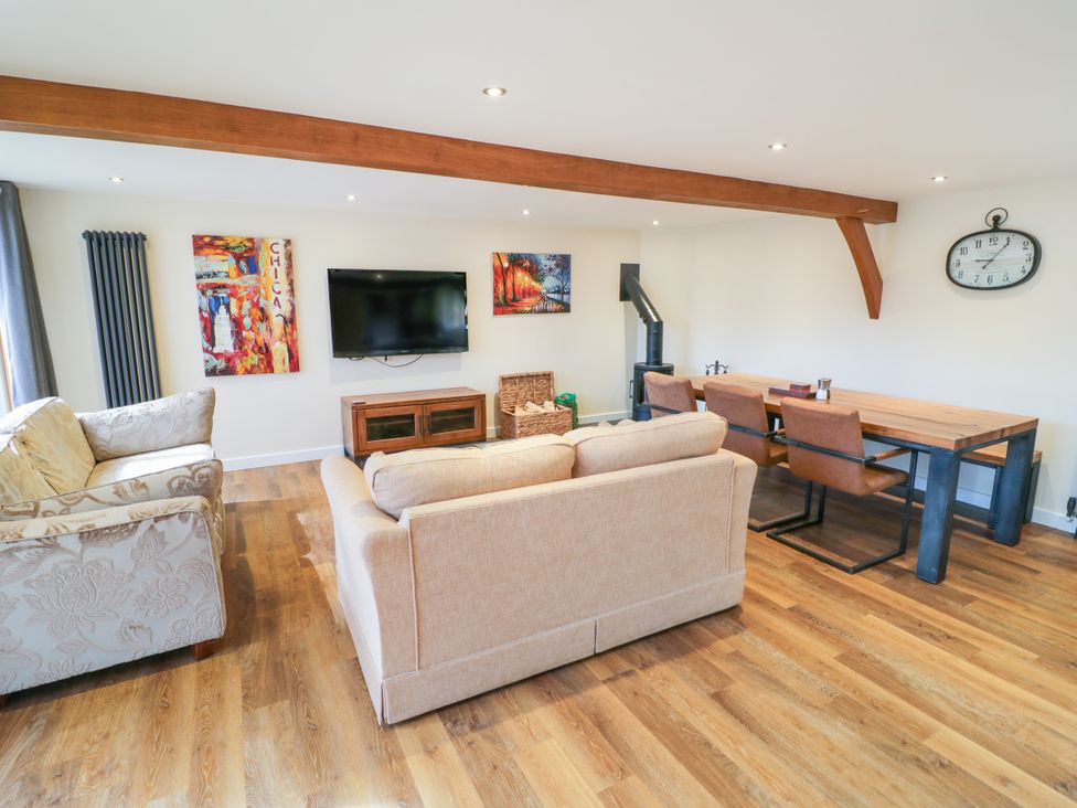 A living room with a television and dining area at The Coach House in Chacombe
