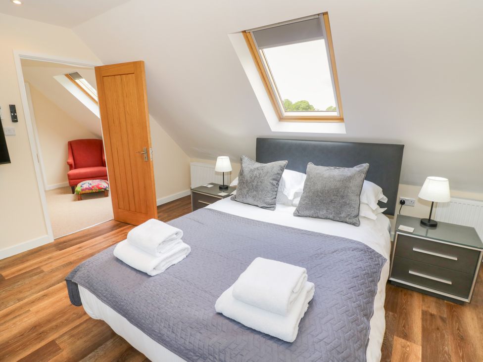 A bedroom with a bed and a chair at The Coach House in Chacombe