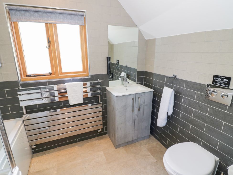 A bathroom with a sink and mirror at The Coach House in Chacombe