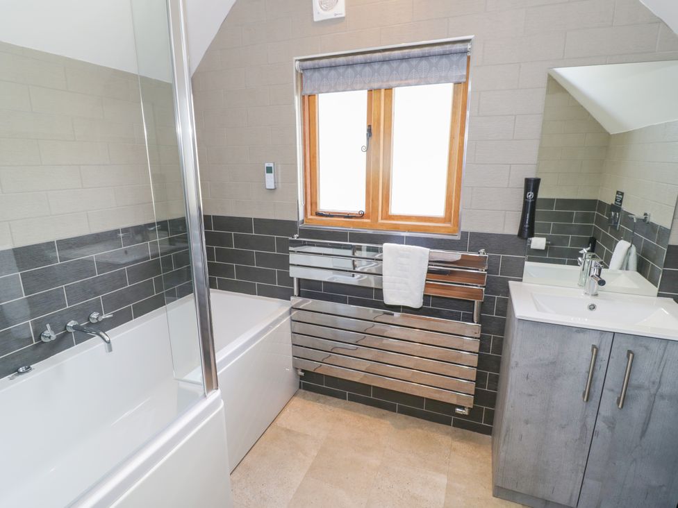 A bathroom with a bathtub and sink at The Coach House in Chacombe