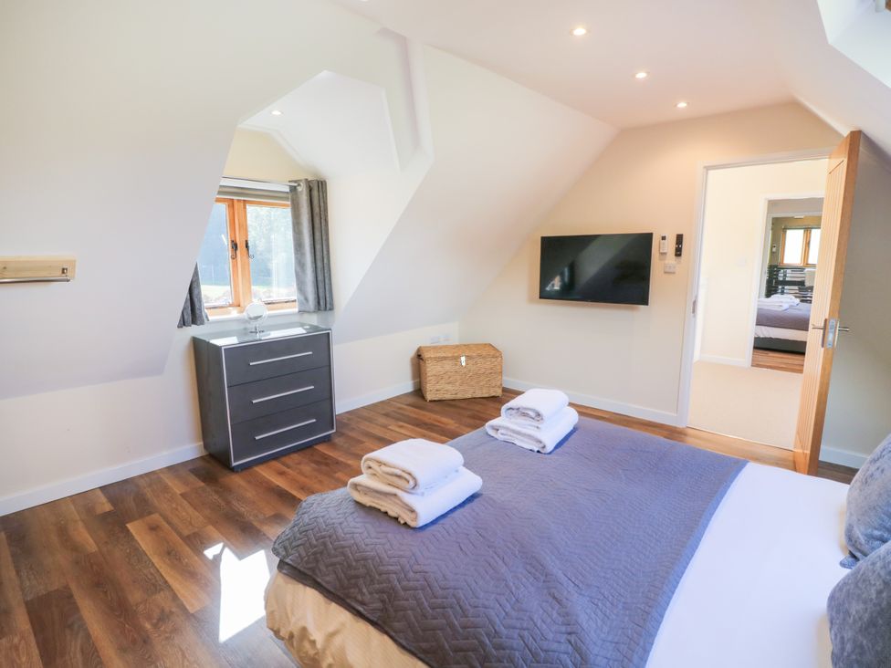A bedroom with a bed and television at The Coach House in Chacombe