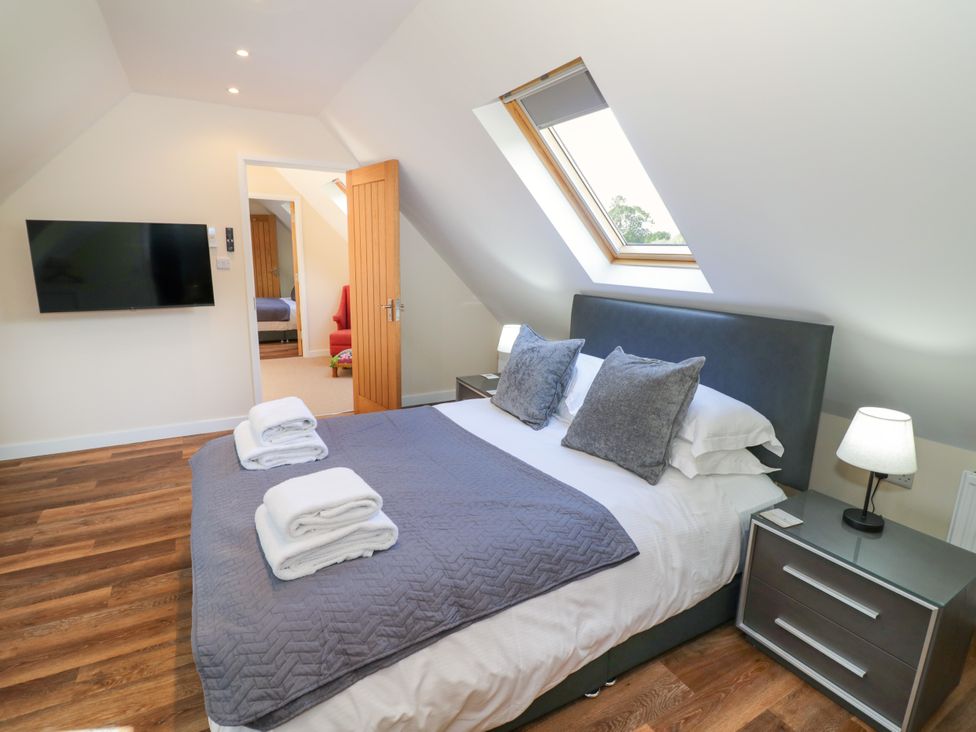 A bedroom with a bed and television at The Coach House in Chacombe