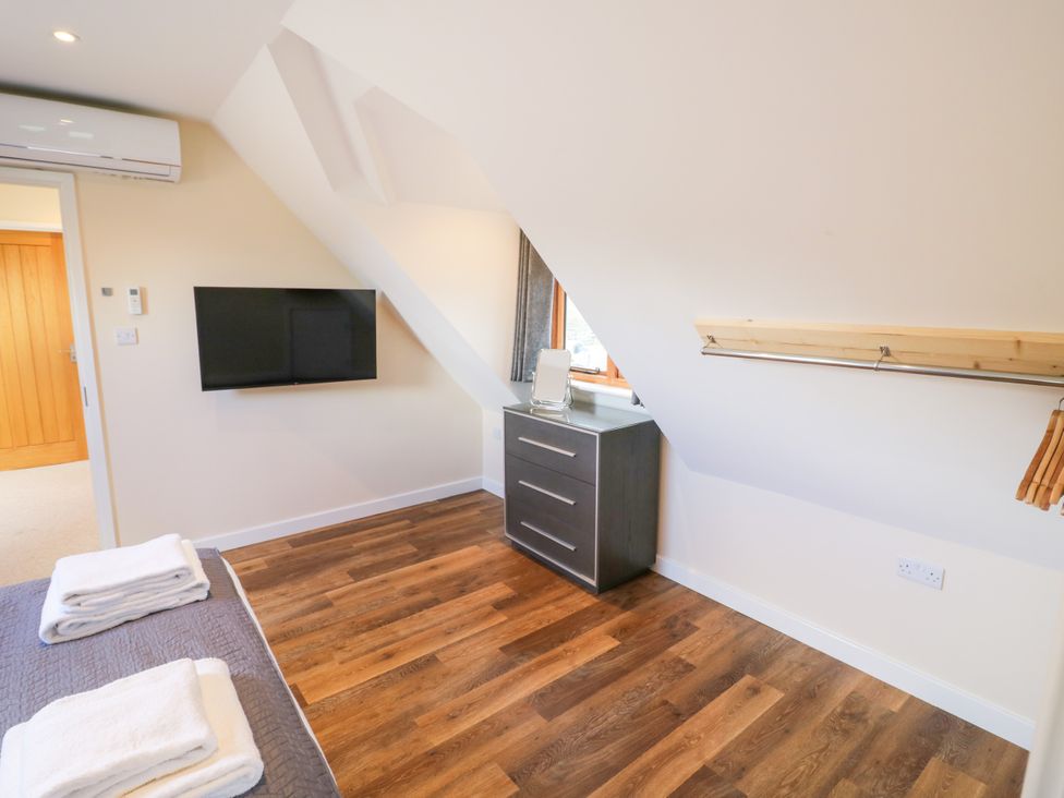 A bedroom with a television and dresser at The Coach House in Chacombe