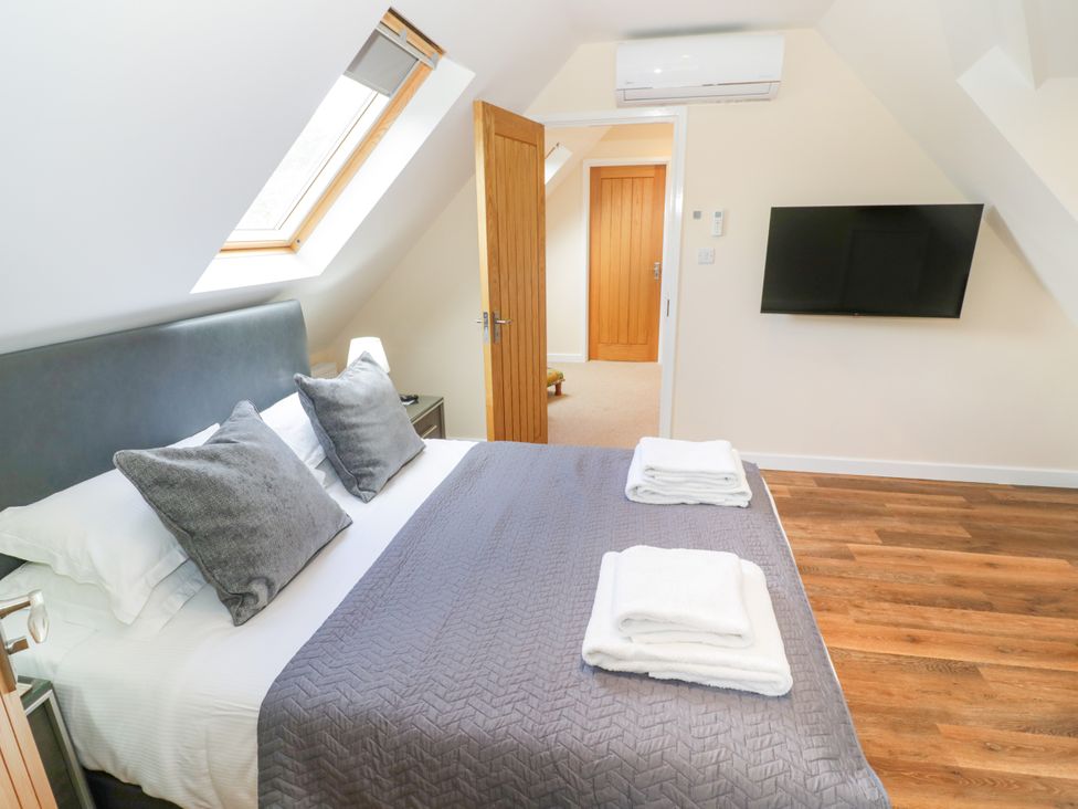 A bedroom with a bed and a TV at The Coach House in Chacombe