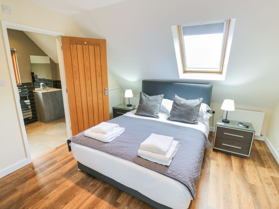 A bedroom with a bed and ensuite bathroom at The Coach House in Chacombe