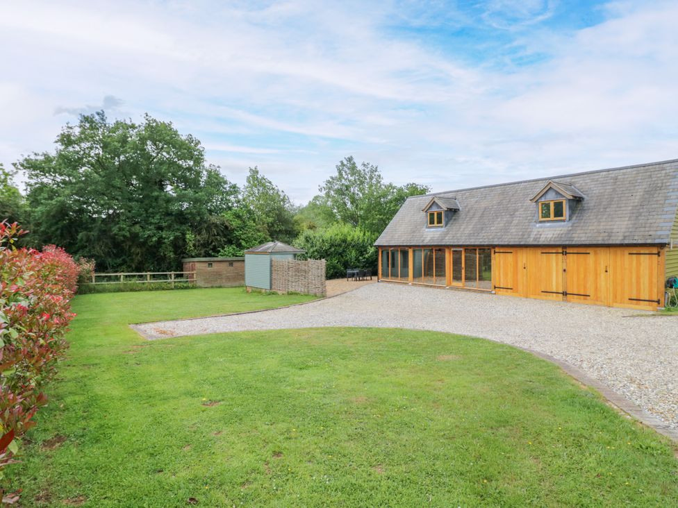 A house and garden area with gravel driveway at The Coach House in Chacombe