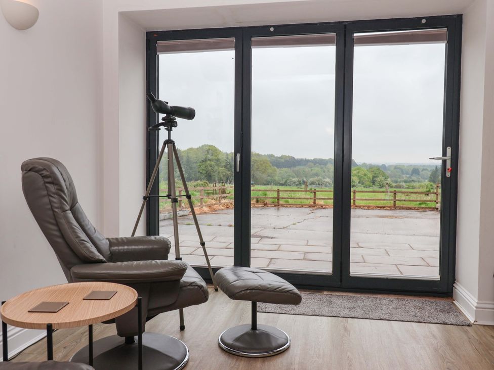 A sitting room with a telescope and sliding doors at Ploughman's Rigg Follifoot near Spofforth
