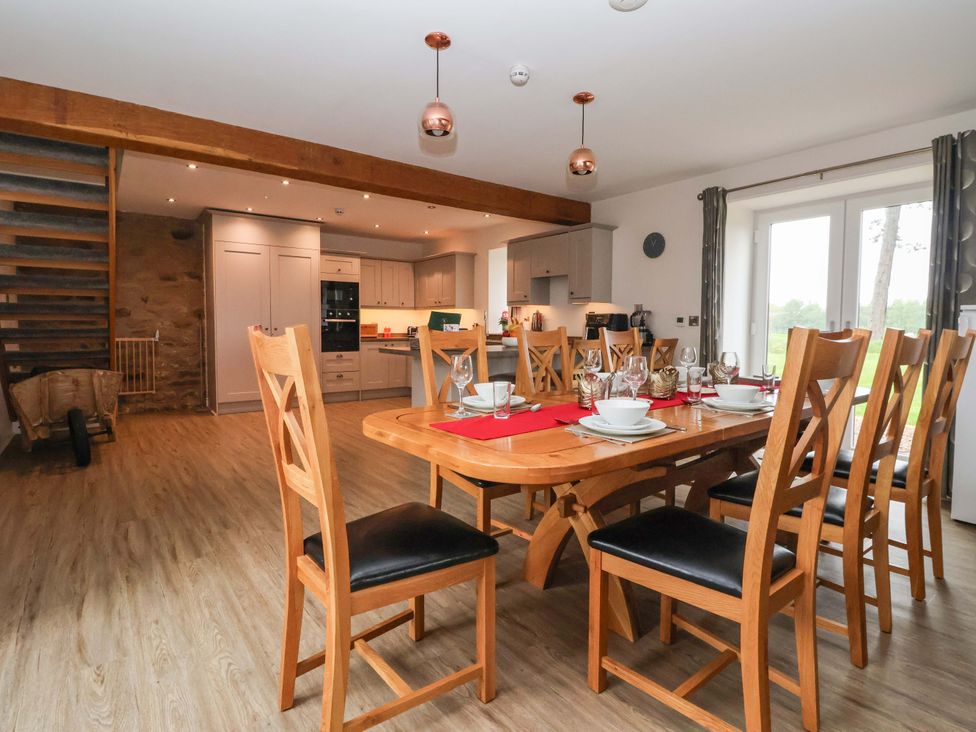 A dining room with a wooden table set for dinner at Ploughman's Rigg Follifoot near Spofforth