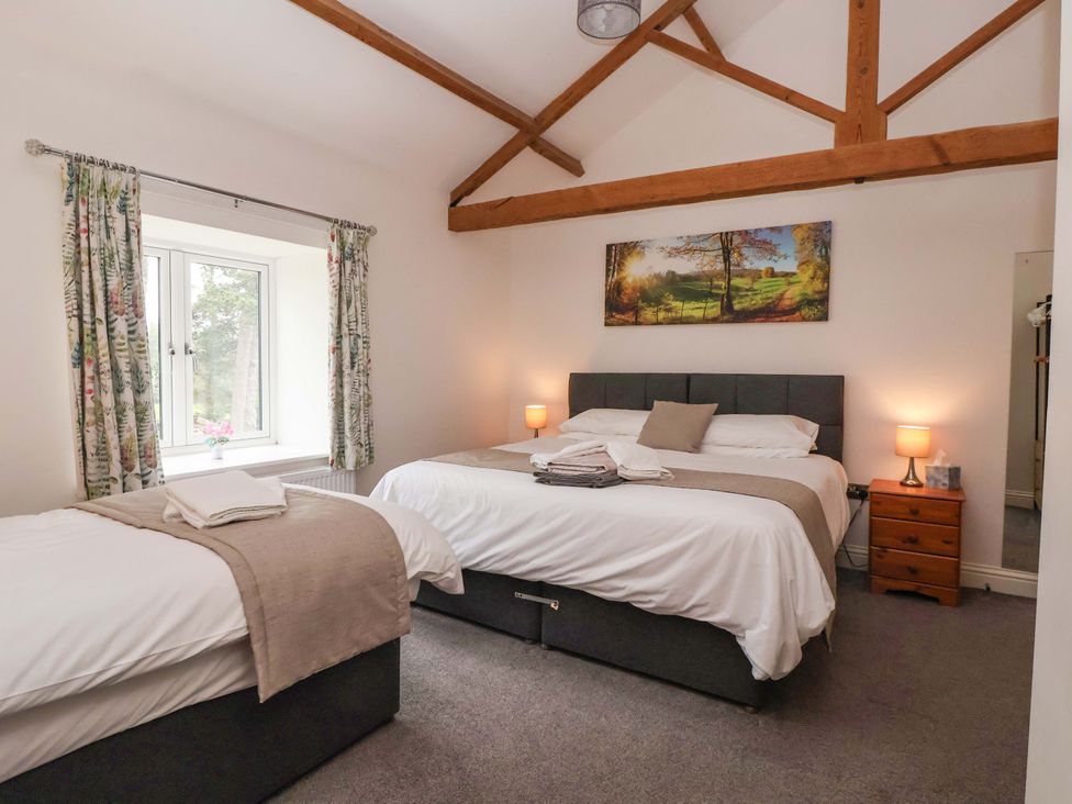 A bedroom with two beds and a window at Ploughman's Rigg in Follifoot near Spofforth