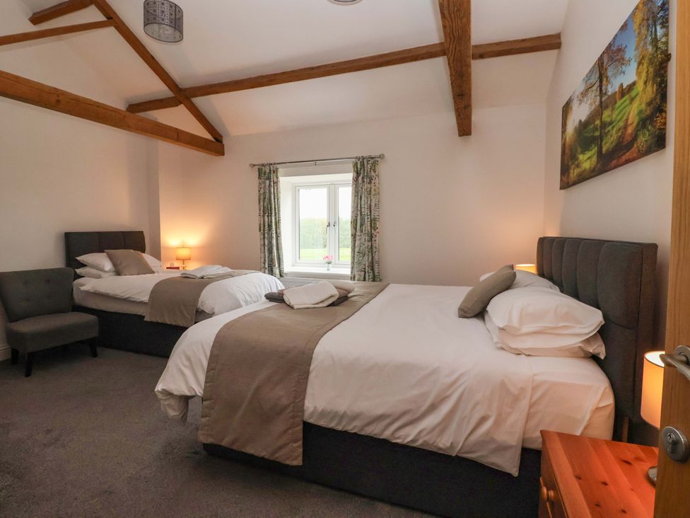 A bedroom with two beds and a window at Ploughman's Rigg in Follifoot near Spofforth