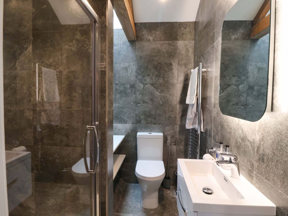 A bathroom with a shower, toilet, sink and towel radiator at Ploughman's Rigg Follifoot near Spofforth