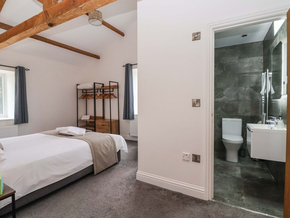 A bedroom with a bed and a bathroom at Ploughman's Rigg in Follifoot near Spofforth
