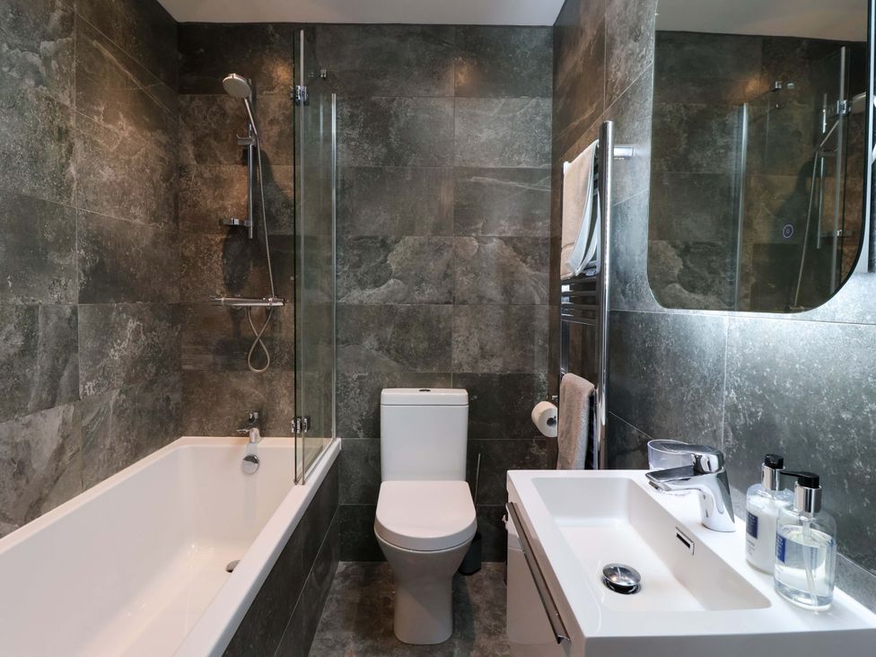 A bathroom with a bathtub, toilet, and sink at Ploughman's Rigg Follifoot near Spofforth