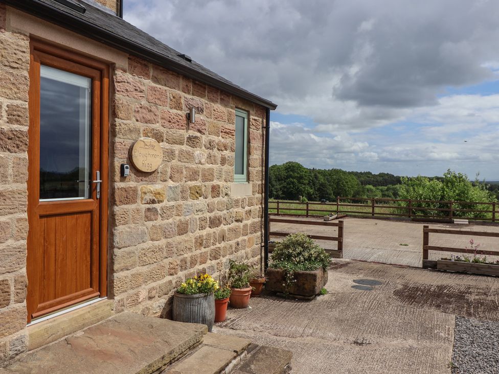 An exterior view of a stone building with potted plants at Ploughman's Rigg Follifoot near Spofforth