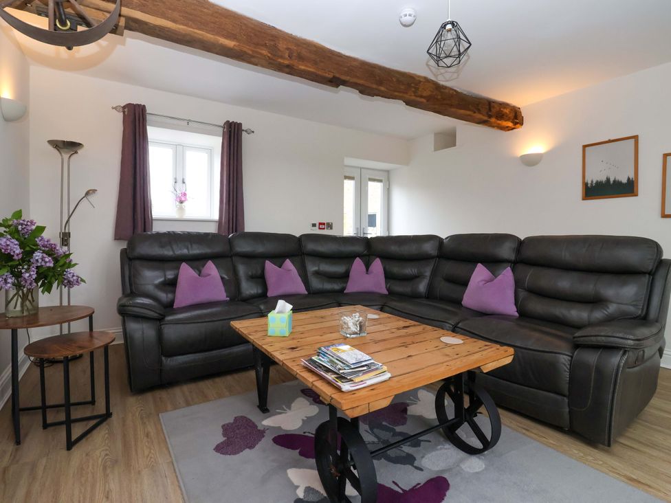 A living room with a sofa and coffee table at Miller's Wheel in Spofforth