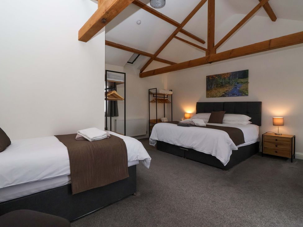A bedroom with beds and a clothes rack at Miller's Wheel in Spofforth