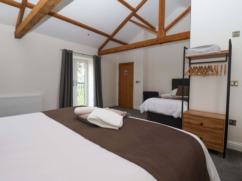 A bedroom with two beds and wooden beams at Miller's Wheel in Spofforth