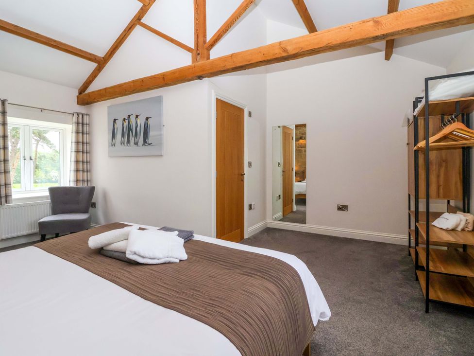 A bedroom with a bed and armchair at Miller's Wheel in Spofforth