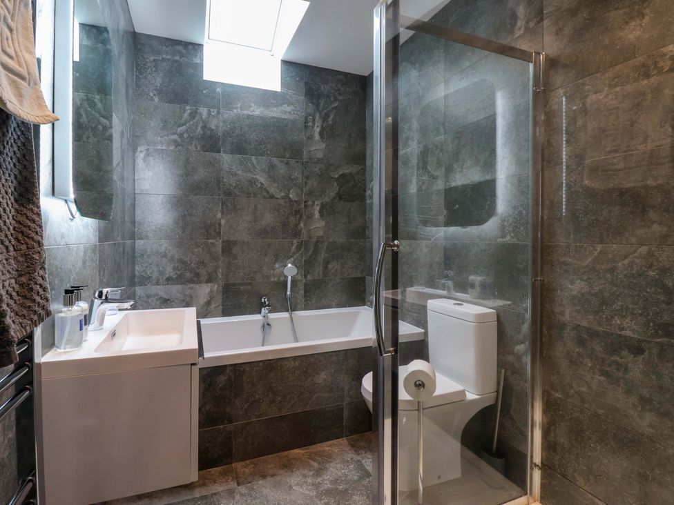 A bathroom with a shower, bathtub, sink, and toilet at Miller's Wheel in Spofforth