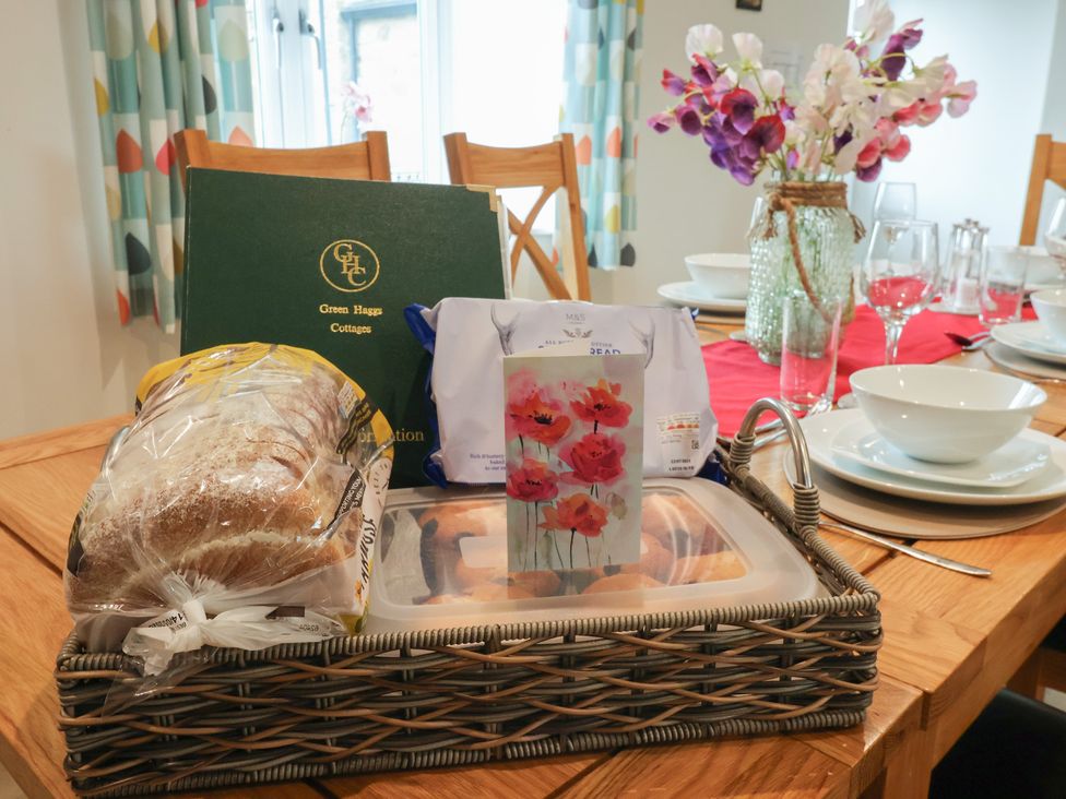 A dining room table with a basket of bread and menu at Miller's Wheel in Spofforth