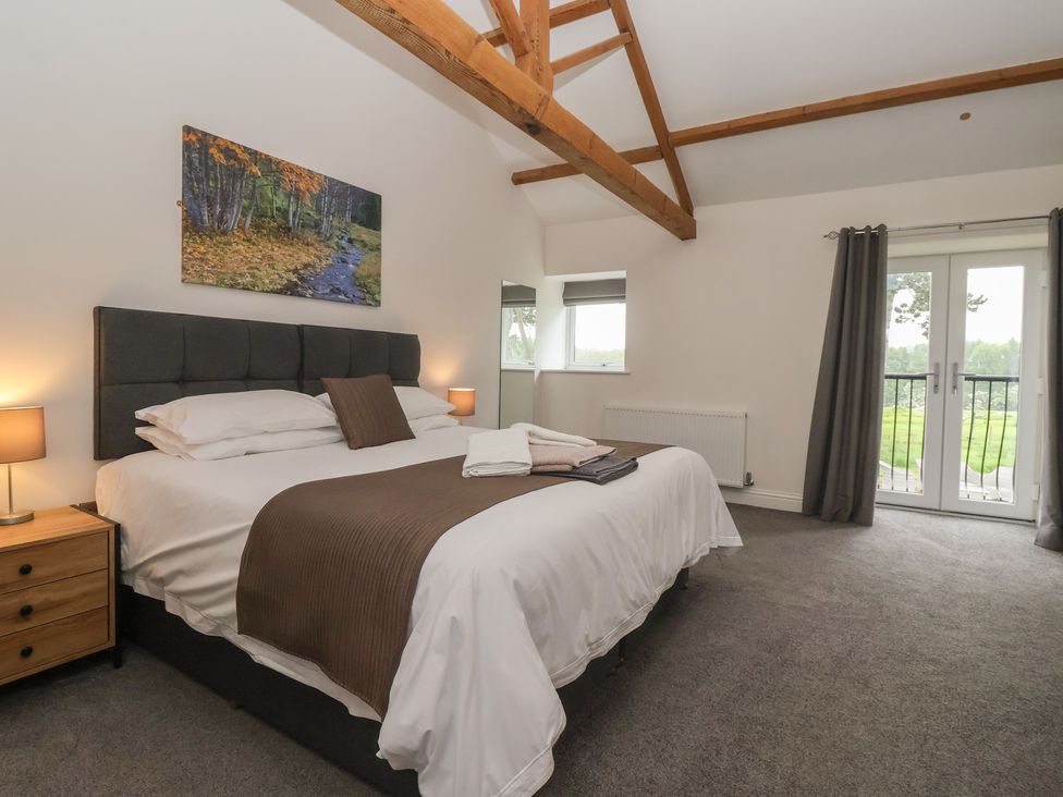 A bedroom with a bed and a door leading outside at Miller's Wheel in Spofforth
