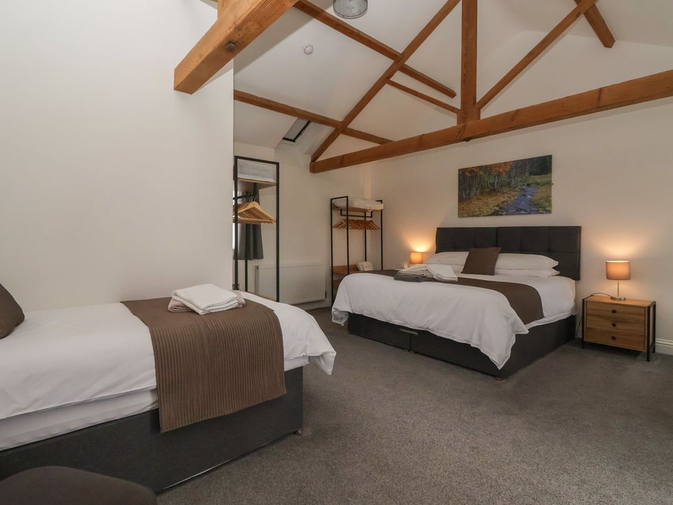 A bedroom with two beds and a wardrobe at Miller's Wheel Spofforth