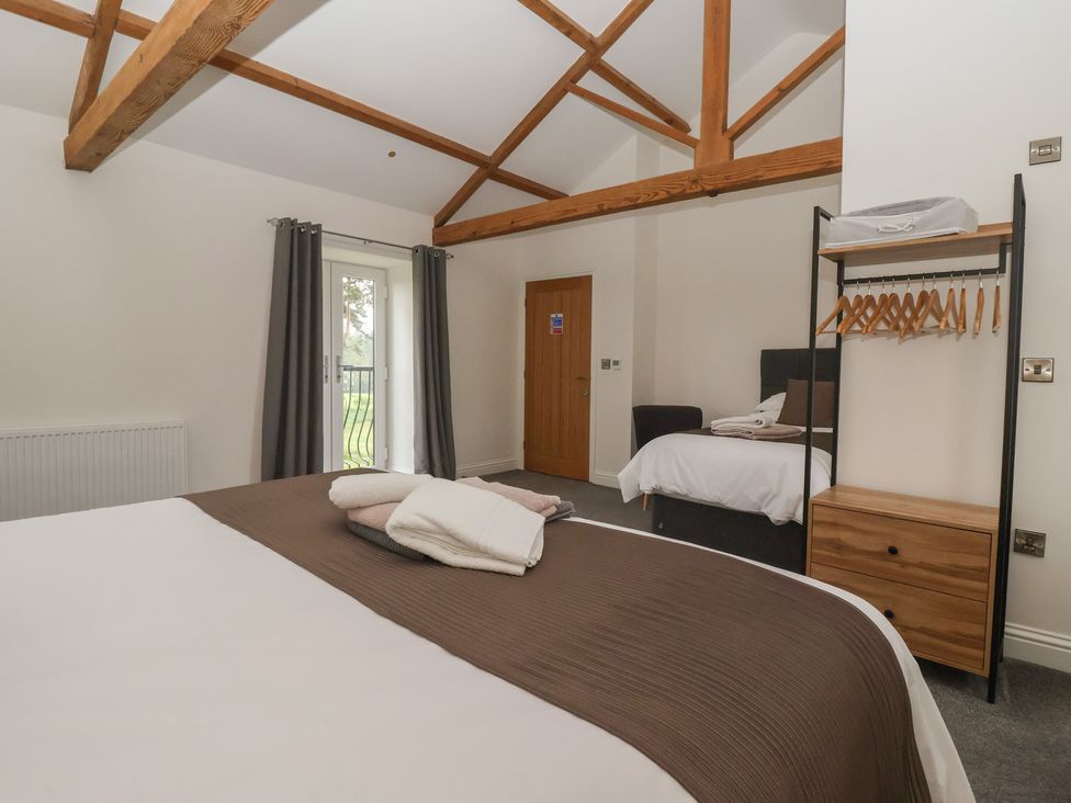 A bedroom with beds and a wardrobe at Miller's Wheel Spofforth