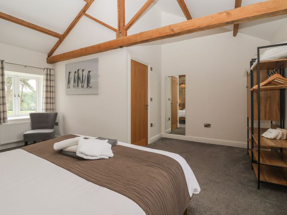 A bedroom with a bed and an armchair at Miller's Wheel in Spofforth