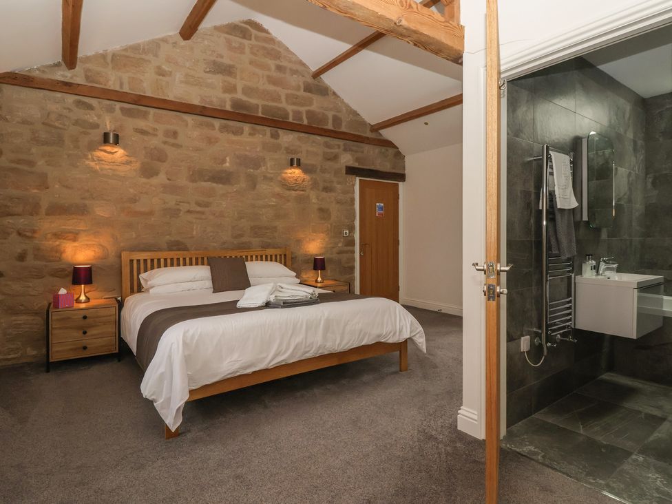 A bedroom with a bed and an ensuite bathroom at Miller's Wheel in Spofforth