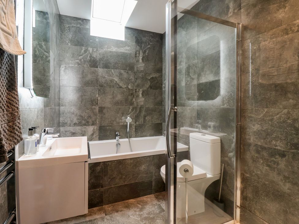 A bathroom with a bathtub, toilet, and sink at Miller's Wheel in Spofforth