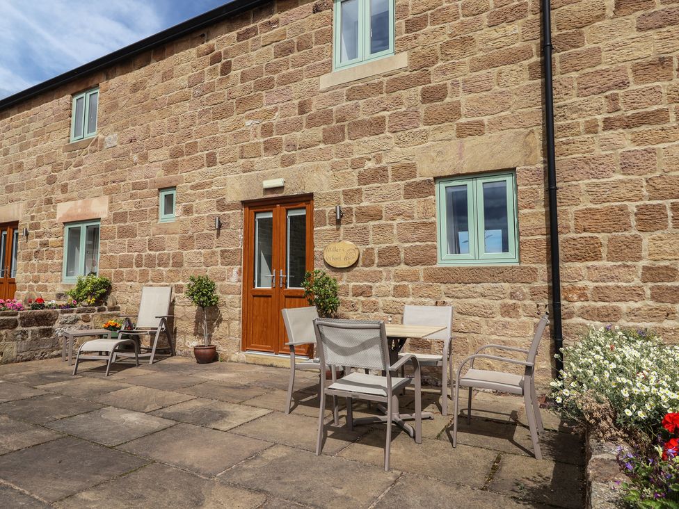 An outdoor seating area with a table and chairs at Miller's Wheel in Spofforth