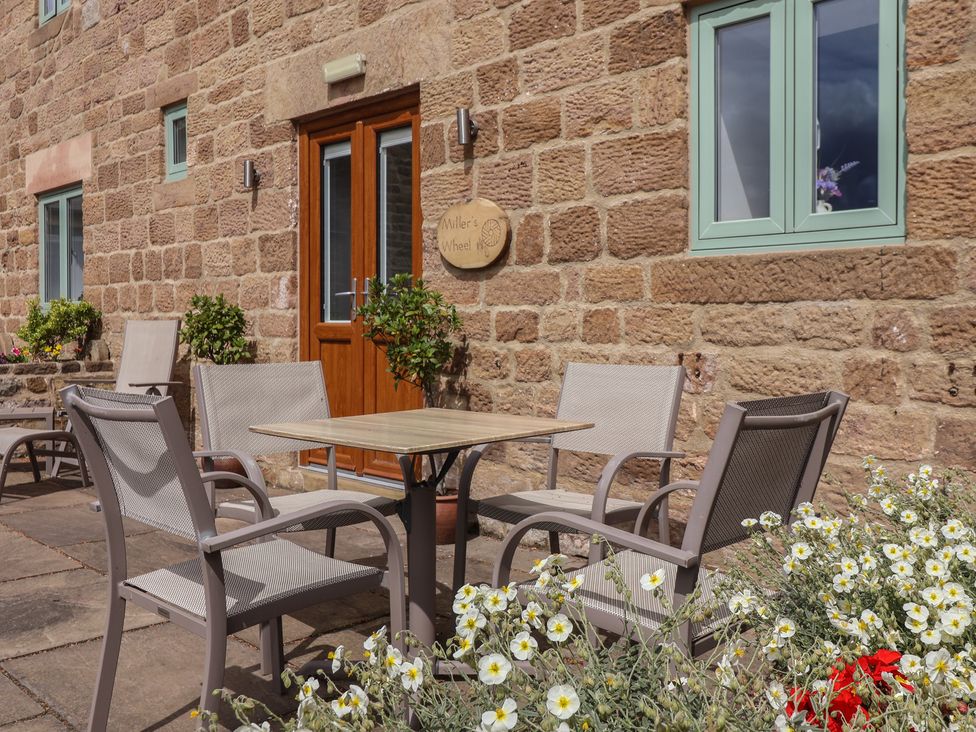 An outdoor seating area with a table and chairs at Miller's Wheel in Spofforth