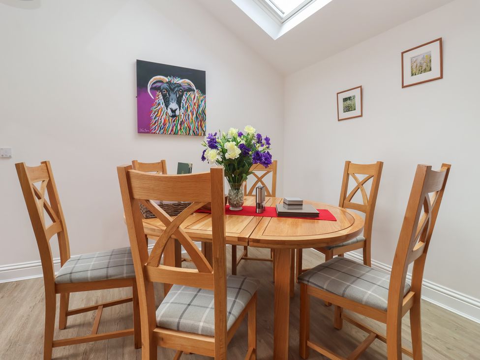 A dining room with a round table and chairs at Shepherd's Crook in Follifoot near Spofforth